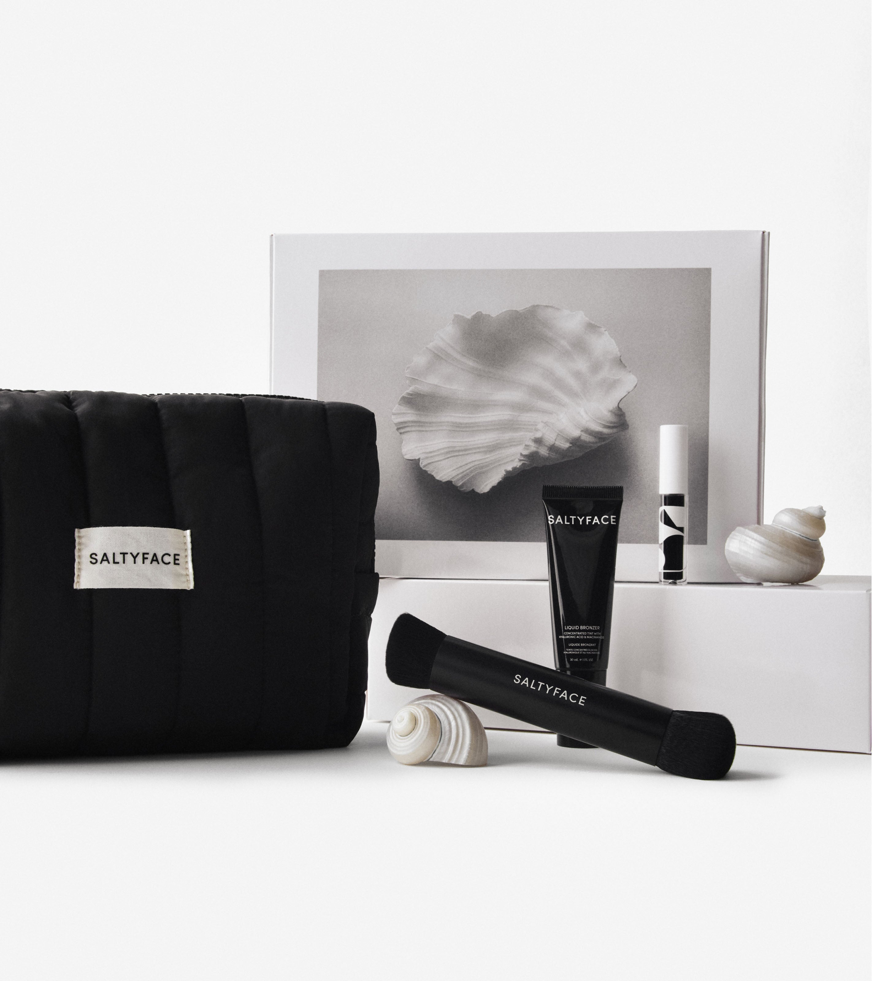 The Everywhere Bag in black, Brush No. 3, Liquid Bronzer, and Freckle Paint are shown together in display with the Saltyface Holiday Gift Box.